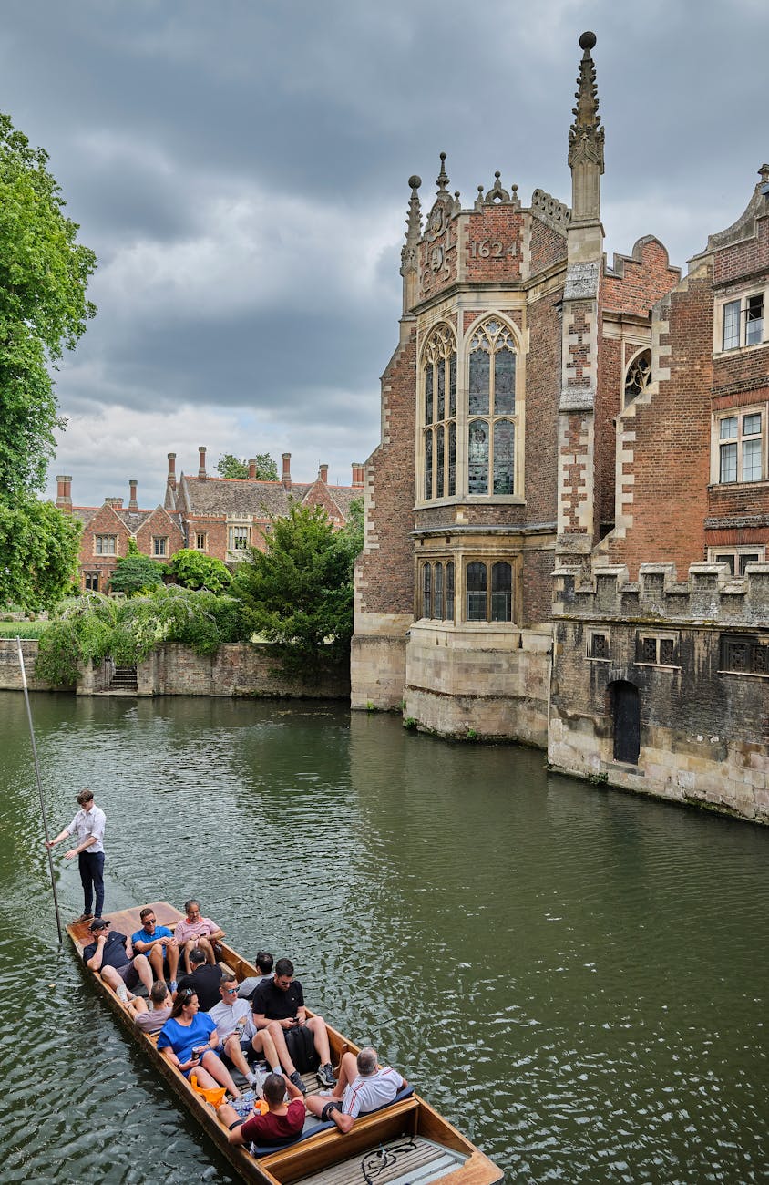 tourists being carried on a boat on the cam river in cambridge