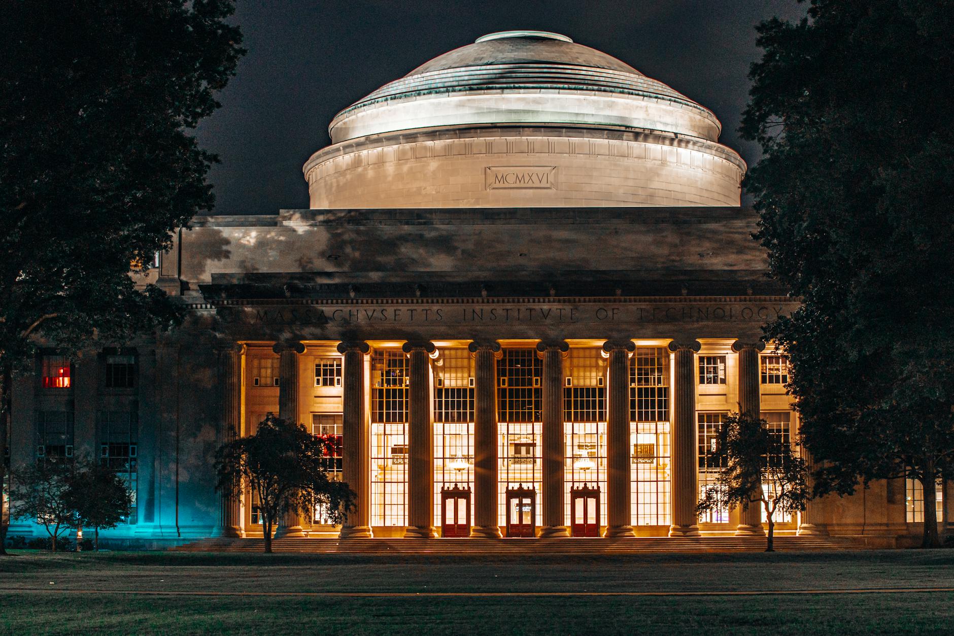 the building is lit up at night with a dome