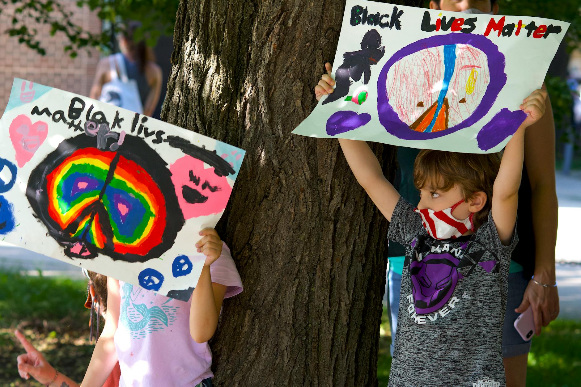 children holding black lives matter painted signs outdoors
